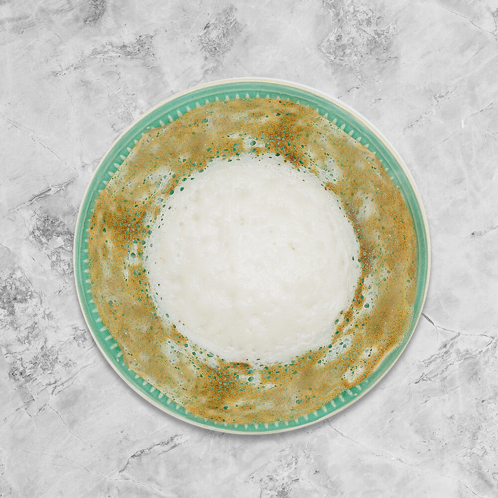 Soft in the centre and crispy on the edges, bowl-shaped fermented rice pancake freshly handmade by Amma Lalli with a perfect pairing of fresh coconut milk. 